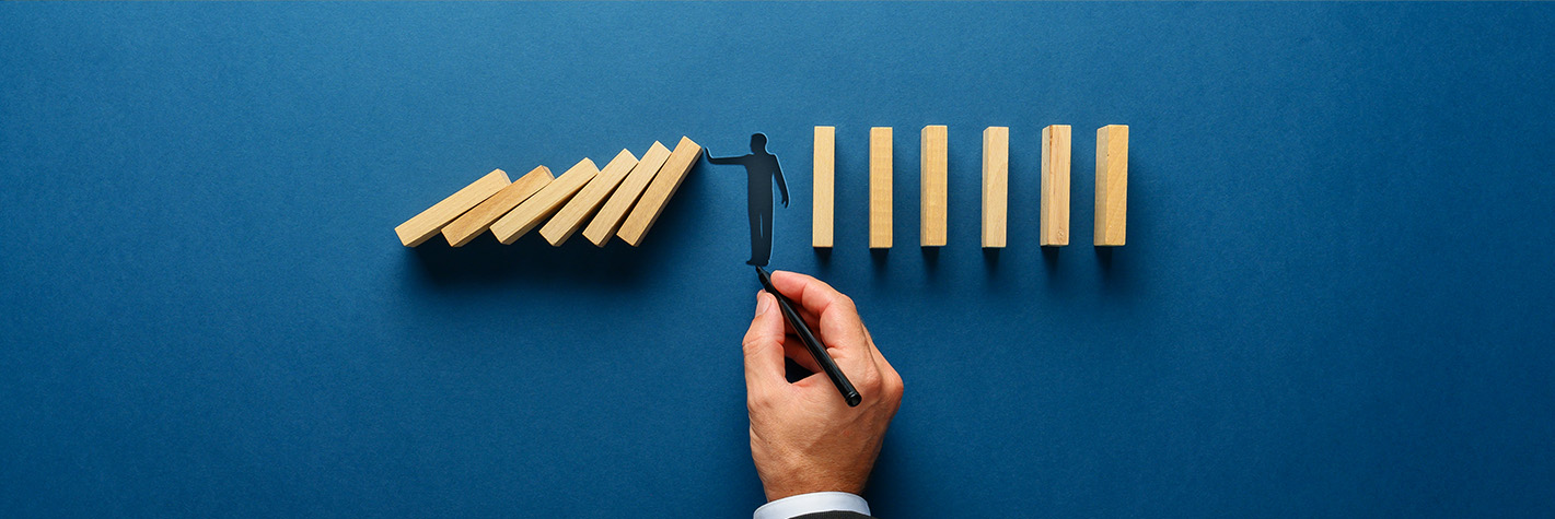 Person managing falling dominoes to illustrate change management